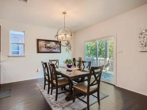 a view of a dining room with furniture wooden floor and chandelier
