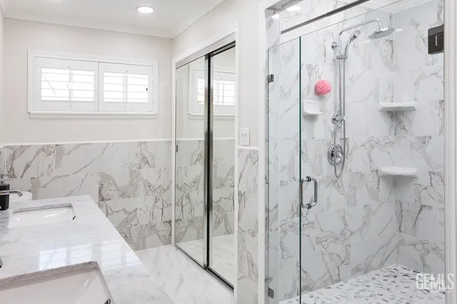 a bathroom with a granite countertop shower and a mirror