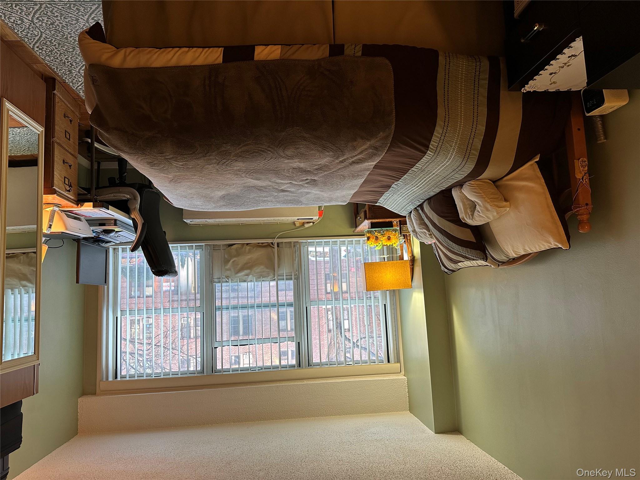 72-35 112th Street, Unit 2E Queens, NY 11375 - Photo 2 of 11 a bed sitting in a bedroom next to a window