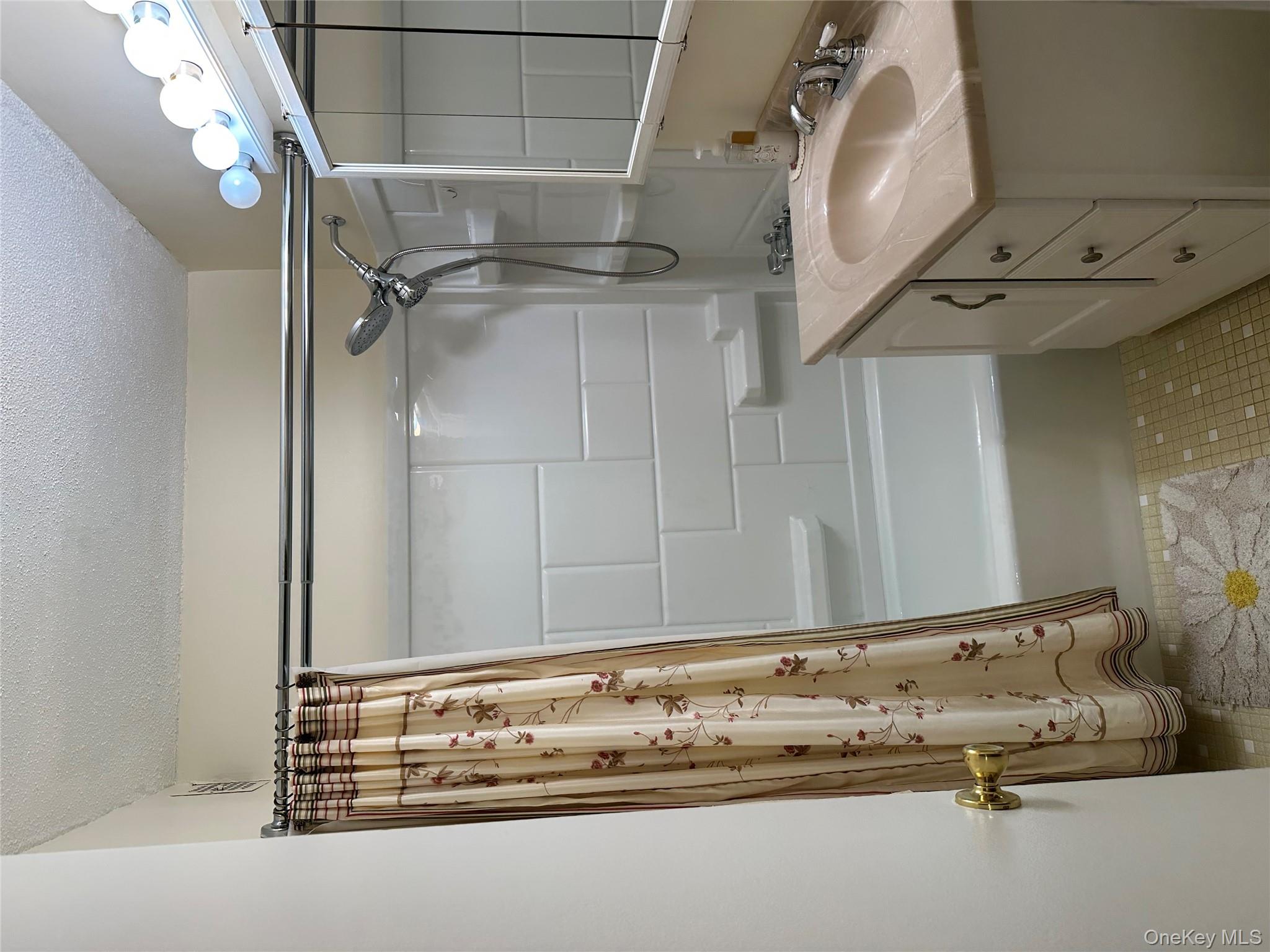 72-35 112th Street, Unit 2E Queens, NY 11375 - Photo 4 of 11 a bathroom with a sink vanity granite tub shower and a mirror