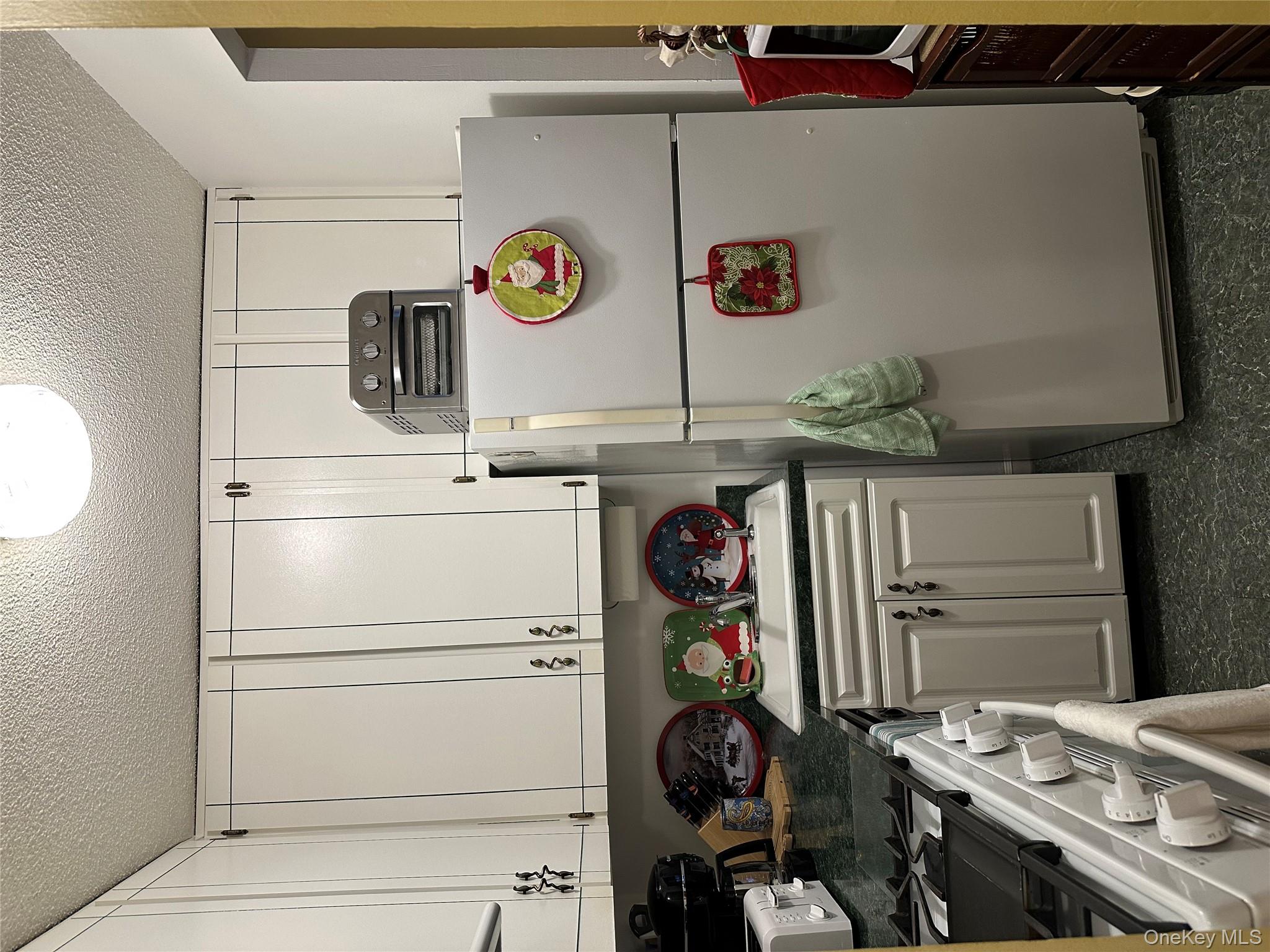 72-35 112th Street, Unit 2E Queens, NY 11375 - Photo 7 of 11 a kitchen with a refrigerator and a stove