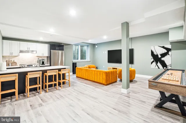 a living room with furniture flat screen tv and pool table