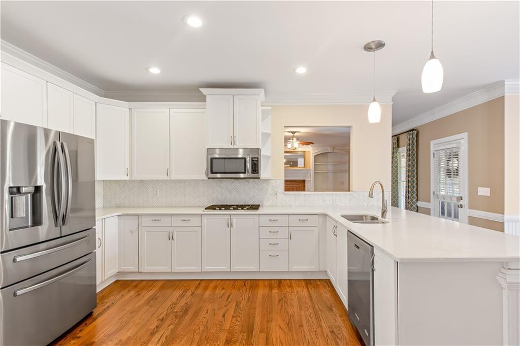 2020 Cockrell Run Northwest Kennesaw, GA 30152 - Photo 23 of 85 a kitchen with stainless steel appliances granite countertop a refrigerator a stove and white cabinets with wooden floor