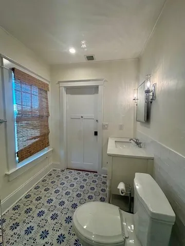 a bathroom with a toilet a sink and mirror