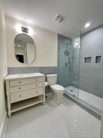 a bathroom with a double vanity sink toilet and shower