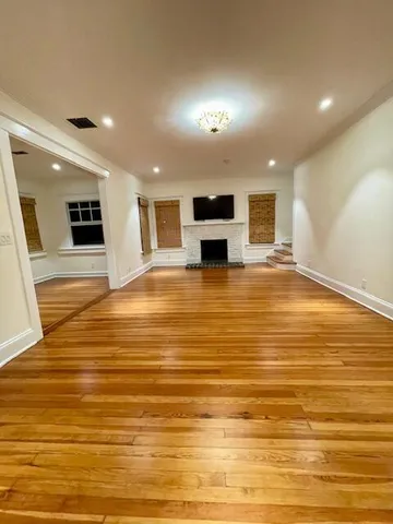 a view of a kitchen with kitchen island a sink stainless steel appliances and cabinets