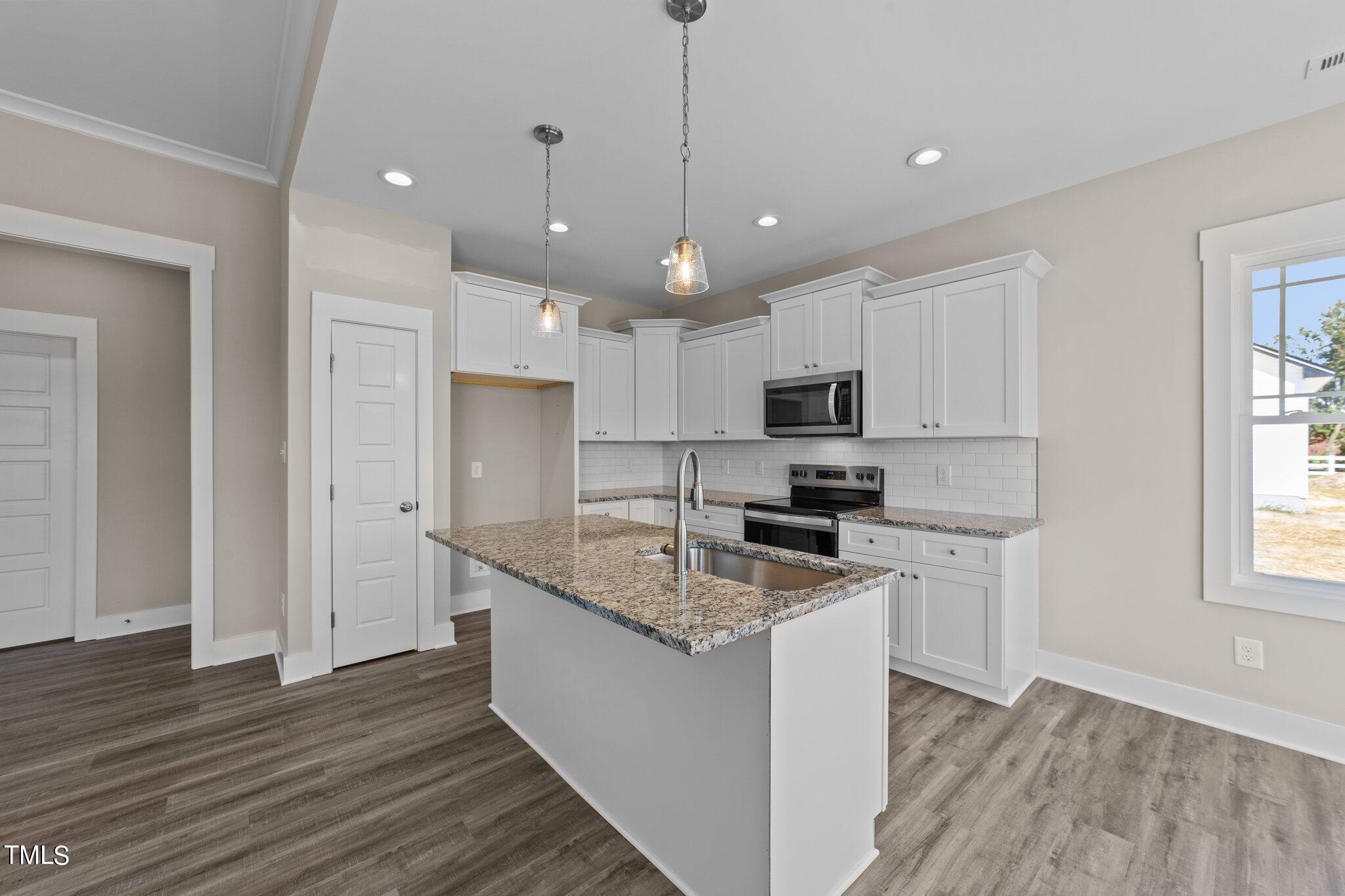 282 Fields Road Pikeville, NC 27863 - Photo 11 of 40 a kitchen with granite countertop a sink a counter space appliances and cabinets