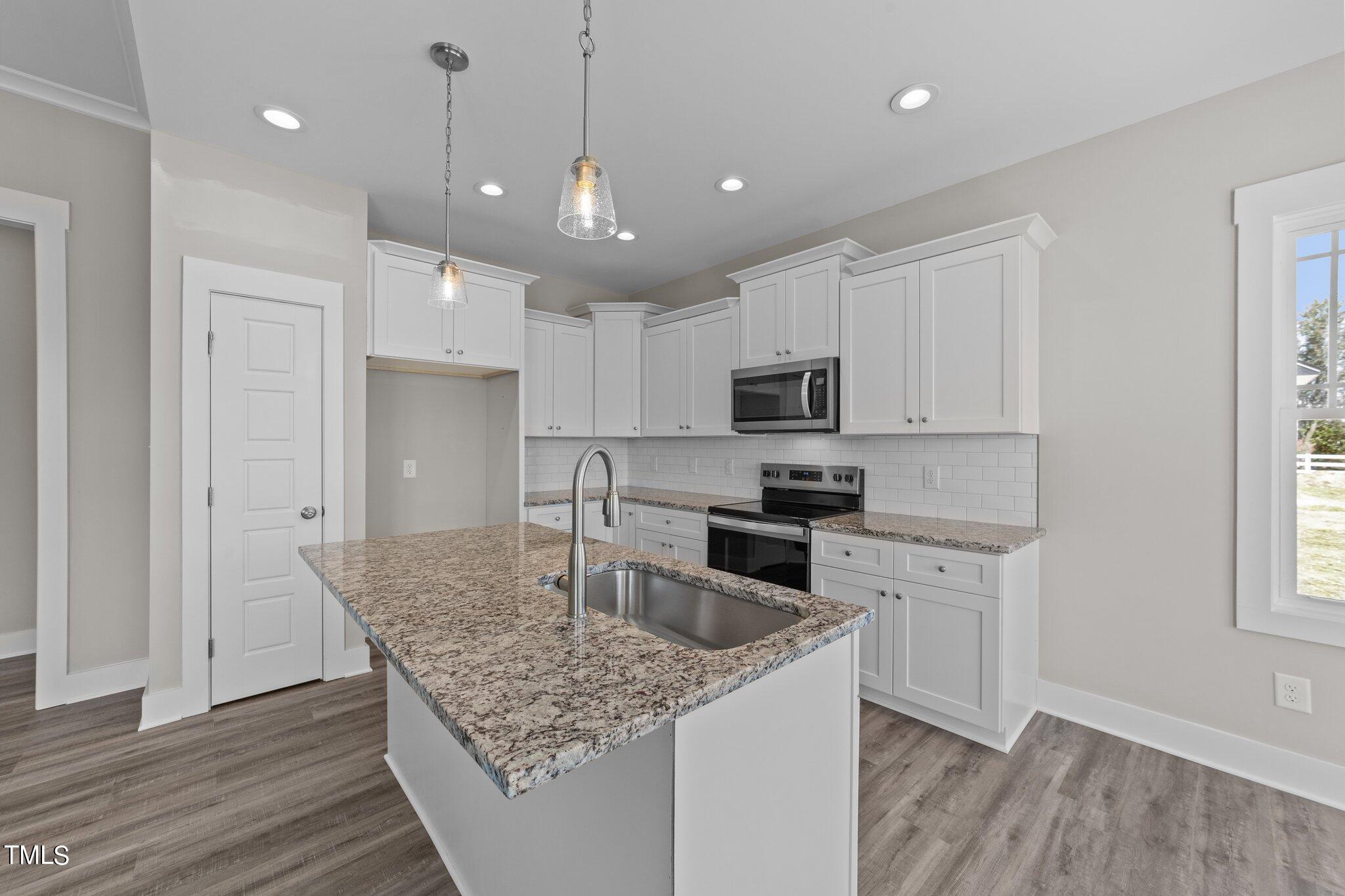 282 Fields Road Pikeville, NC 27863 - Photo 12 of 40 a kitchen with kitchen island granite countertop a sink refrigerator and cabinets