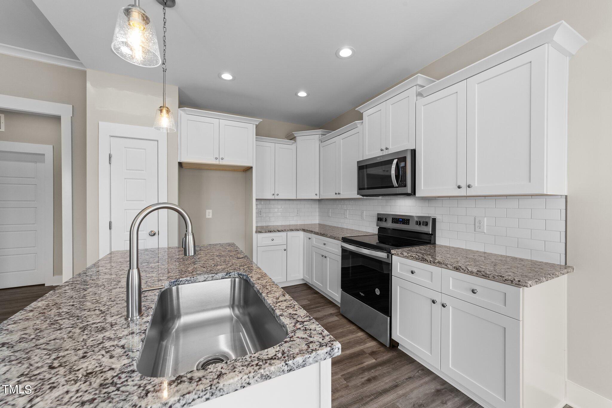 282 Fields Road Pikeville, NC 27863 - Photo 13 of 40 a kitchen with granite countertop a sink stainless steel appliances and white cabinets