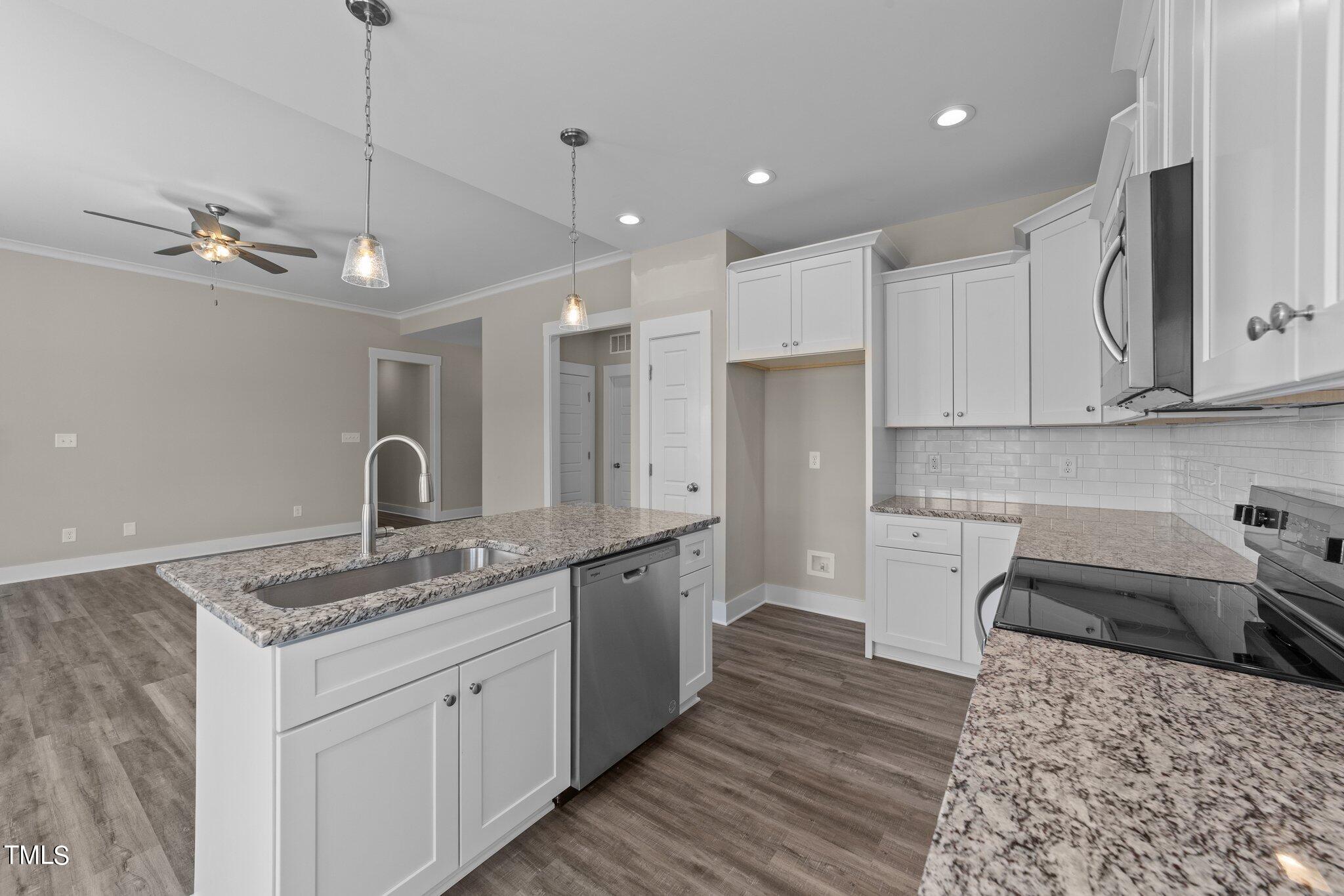 282 Fields Road Pikeville, NC 27863 - Photo 15 of 40 a kitchen with a sink dishwasher a stove a refrigerator and cabinets with wooden floor