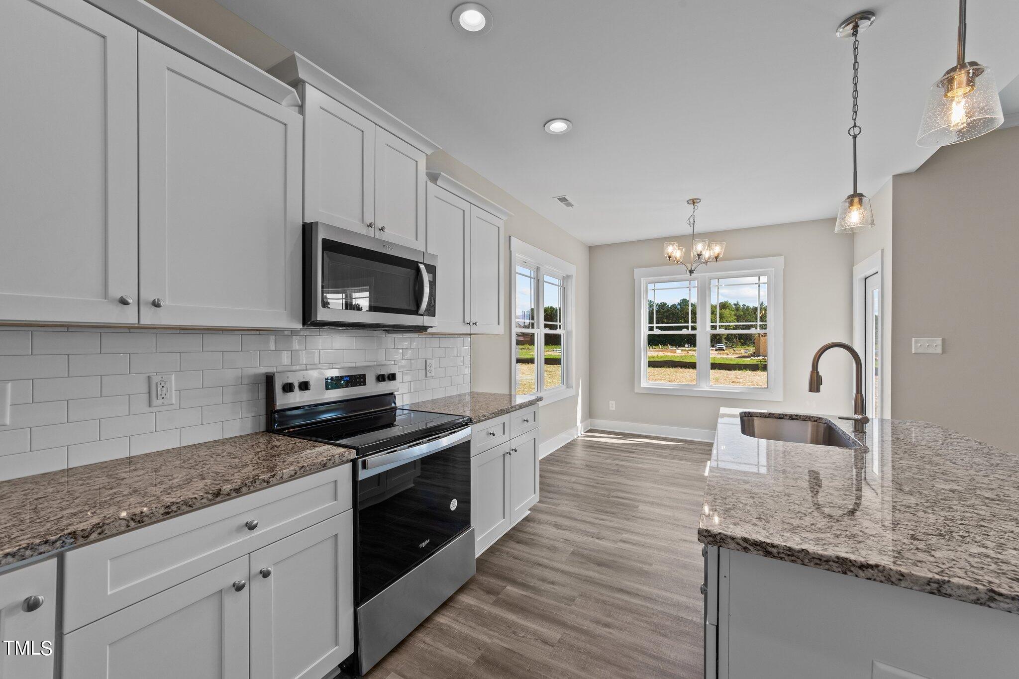 282 Fields Road Pikeville, NC 27863 - Photo 17 of 40 a kitchen with granite countertop a sink a stove and cabinets