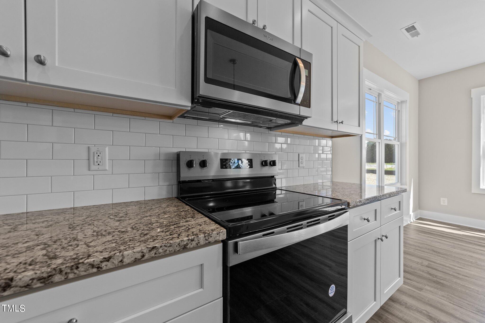 282 Fields Road Pikeville, NC 27863 - Photo 18 of 40 a kitchen with stainless steel appliances granite countertop a stove and a microwave