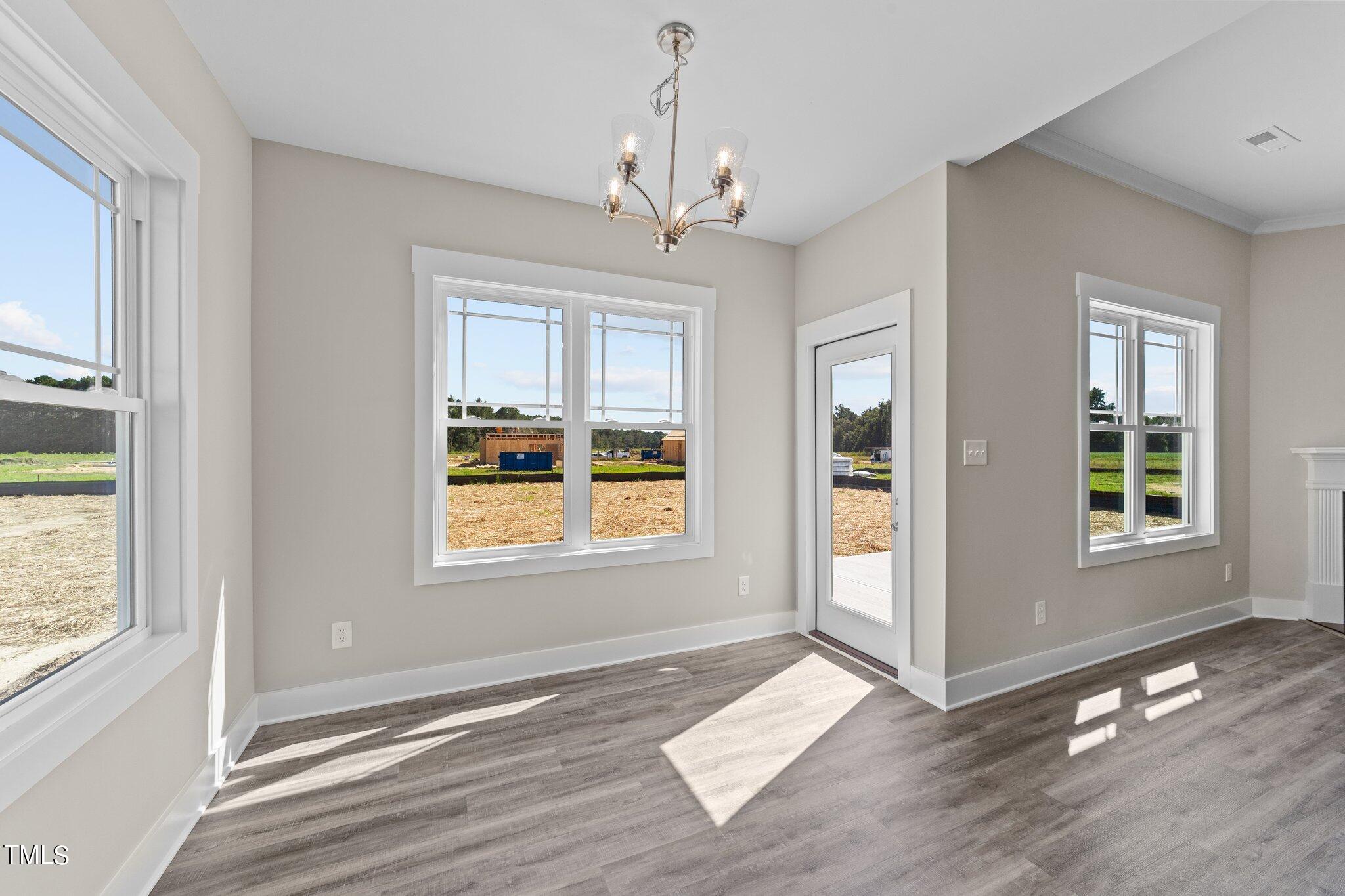 282 Fields Road Pikeville, NC 27863 - Photo 19 of 40 a view of an empty room with wooden floor and a window