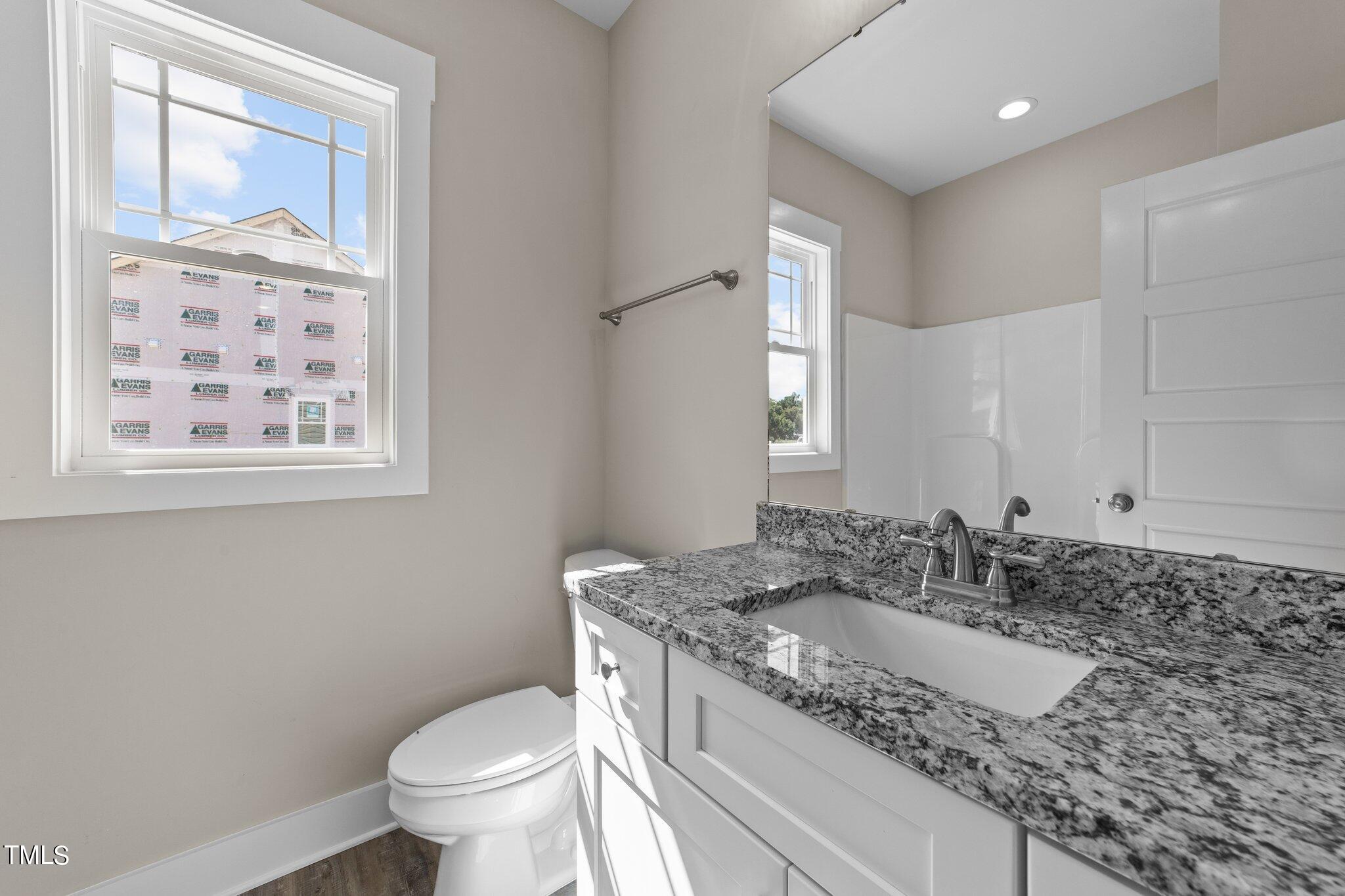 282 Fields Road Pikeville, NC 27863 - Photo 27 of 40 a bathroom with a granite countertop sink mirror vanity and toilet