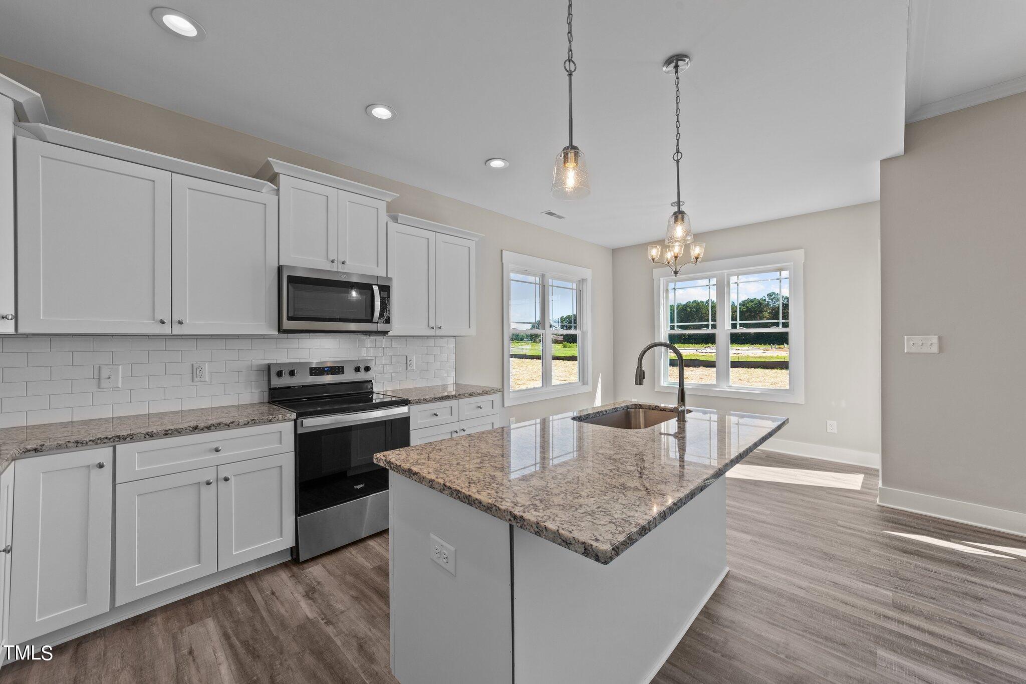 282 Fields Road Pikeville, NC 27863 - Photo 9 of 40 a kitchen with stainless steel appliances granite countertop stove microwave and wooden floor