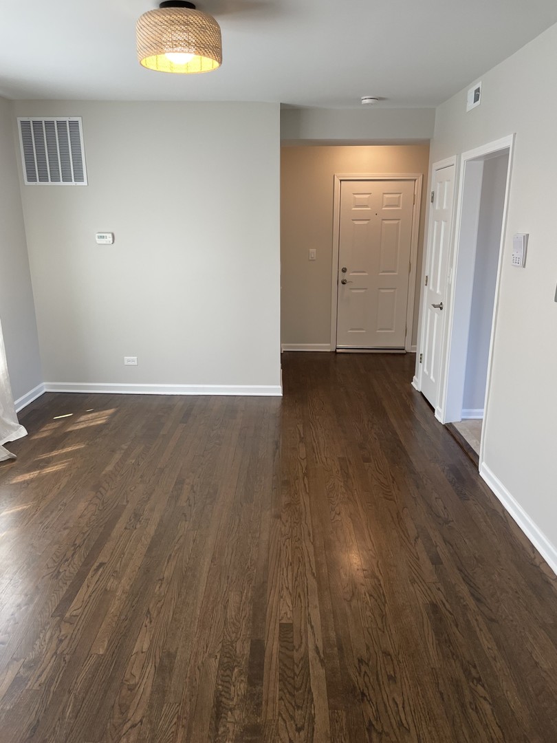 7318 North Honore Street, Unit 403 Chicago, IL 60626 - Photo 2 of 15 an empty room with wooden floor and closet