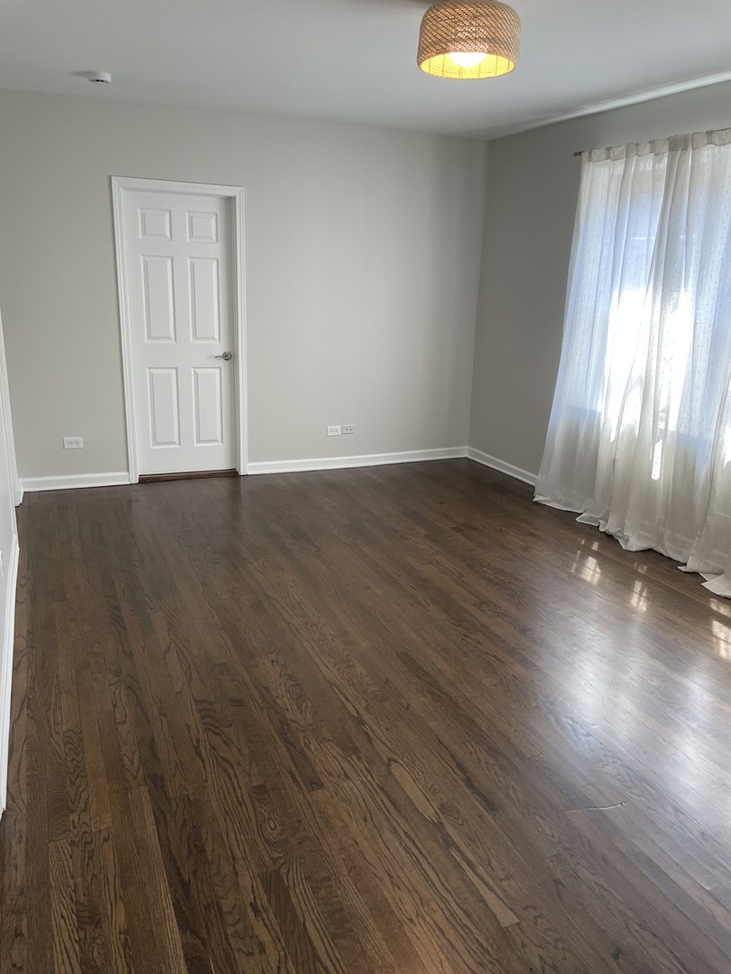 7318 North Honore Street, Unit 403 Chicago, IL 60626 - Photo 3 of 15 an empty room with wooden floor and windows