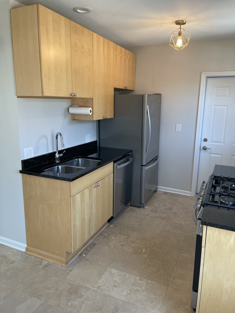 7318 North Honore Street, Unit 403 Chicago, IL 60626 - Photo 4 of 15 a kitchen with stainless steel appliances granite countertop a stove a refrigerator and a sink