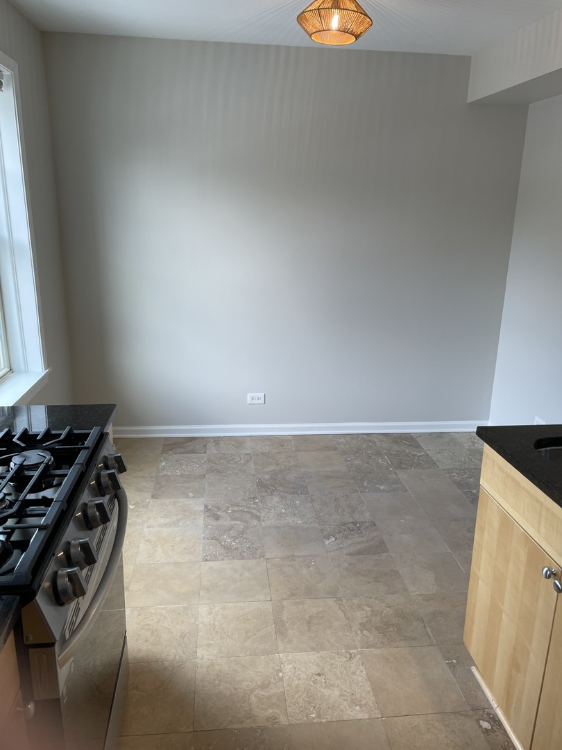 7318 North Honore Street, Unit 403 Chicago, IL 60626 - Photo 6 of 15 a kitchen with granite countertop a stove and a sink
