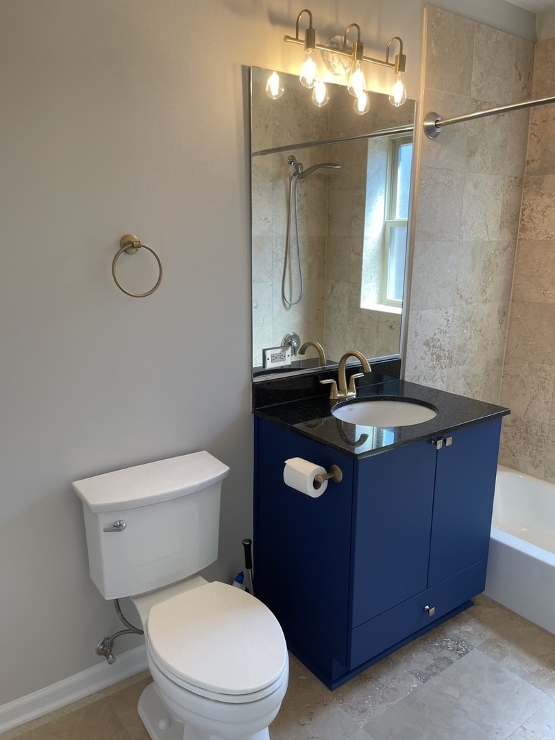 7318 North Honore Street, Unit 403 Chicago, IL 60626 - Photo 7 of 15 a bathroom with a toilet sink vanity and mirror