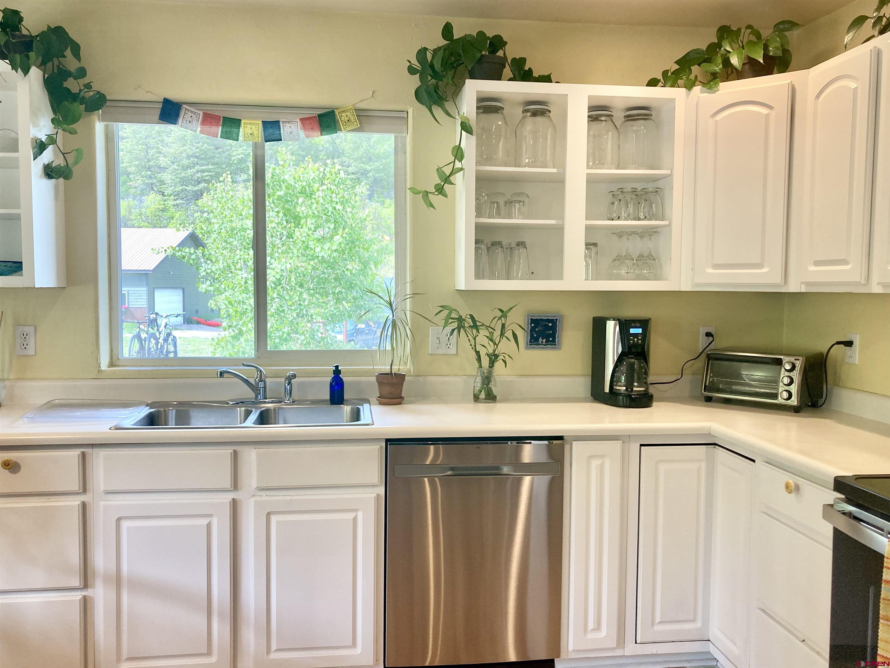 56 Bad Mule Road Durango, CO 81301 - Photo 12 of 35 a kitchen with stainless steel appliances granite countertop a sink a stove and a white cabinets