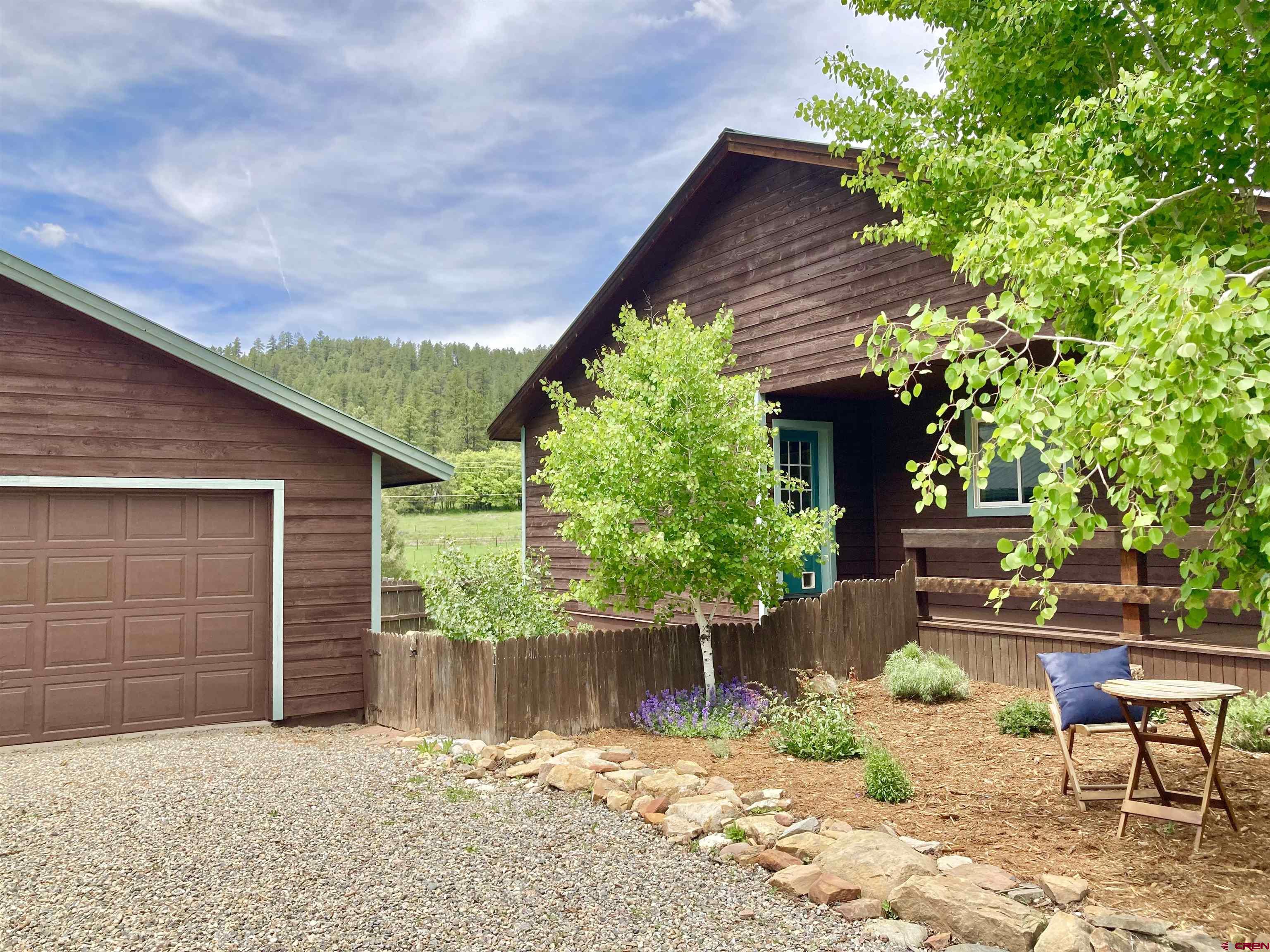 56 Bad Mule Road Durango, CO 81301 - Photo 32 of 35 a backyard of a house with table and chairs and wooden fence