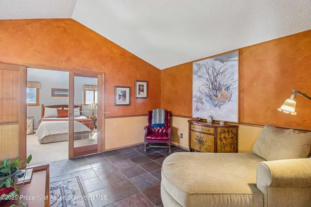 a spacious bedroom with a bed and a flat screen television