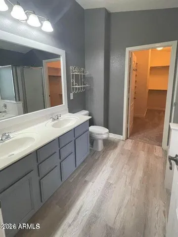 a spacious bathroom with a sink a toilet and a mirror