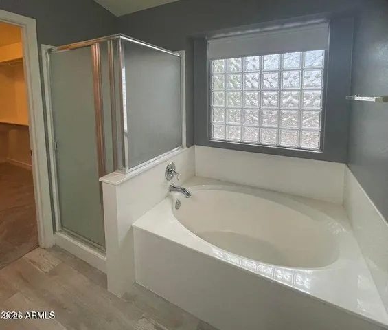 a white bath tub sitting in a bathroom next to a window