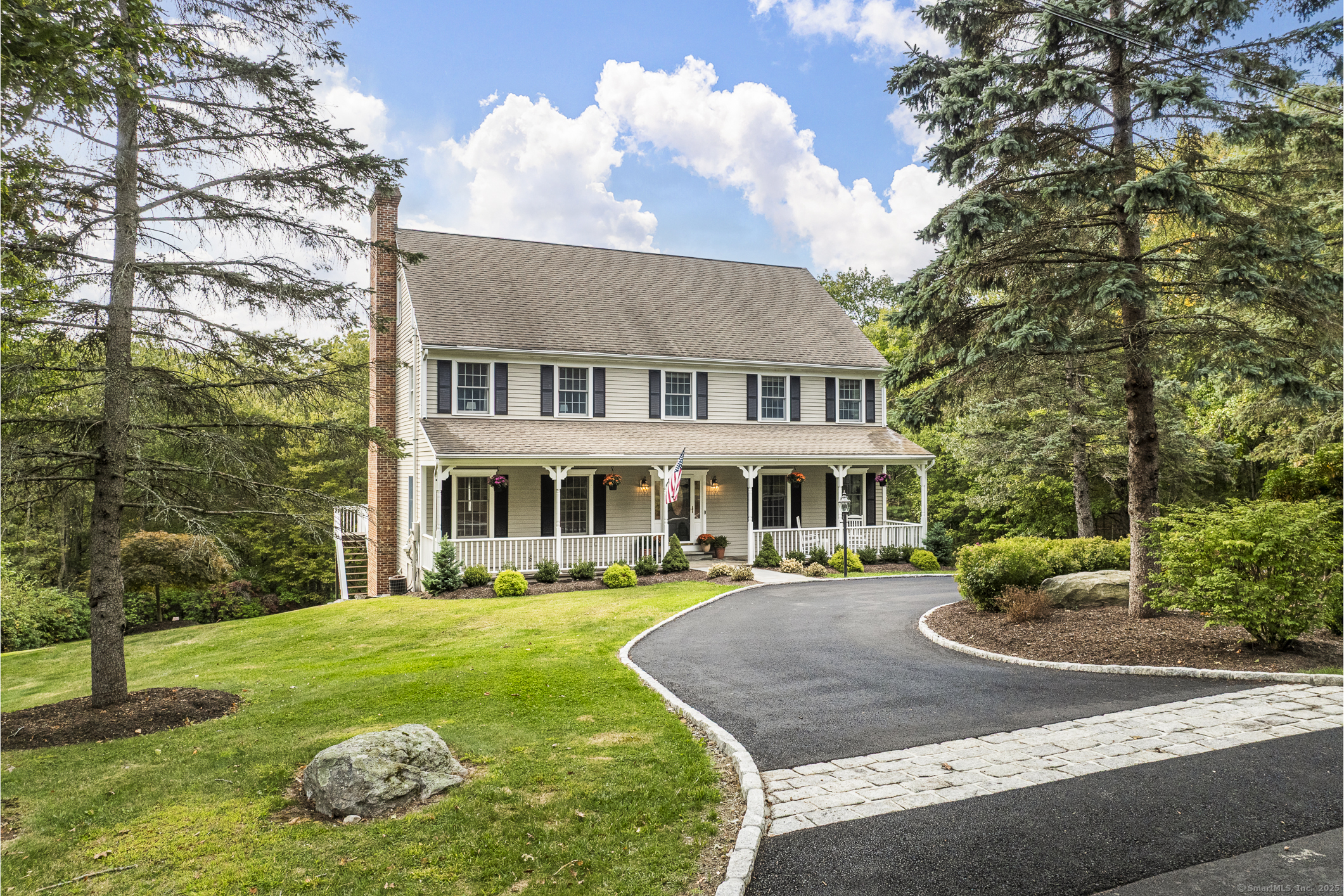 a front view of a house with garden and trees