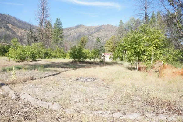 a view of dirt road with a building in the background