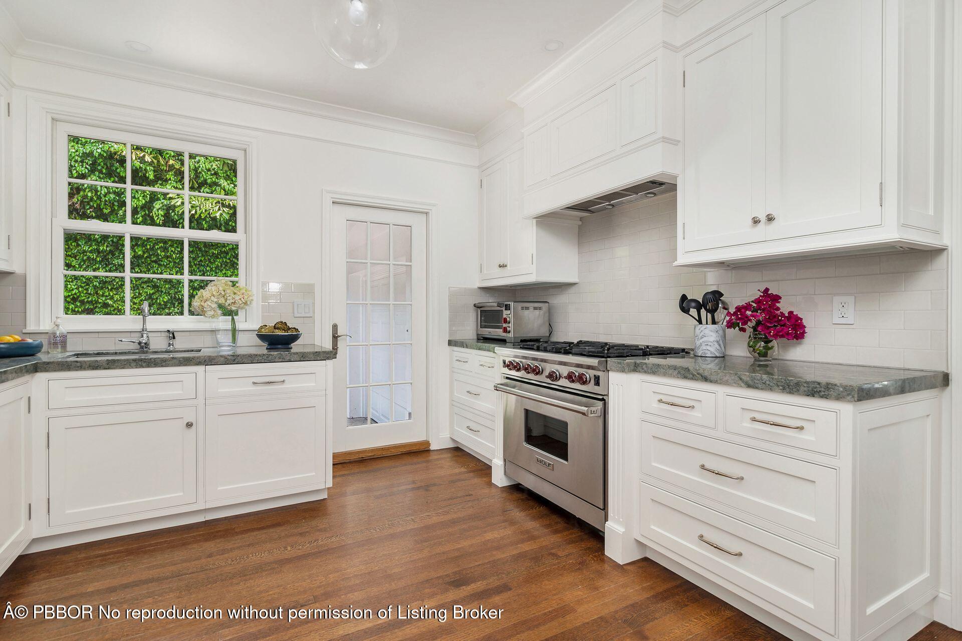 255 Colonial Lane Palm Beach, FL 33480 - Photo 10 of 32 a kitchen with granite countertop white cabinets and white appliances