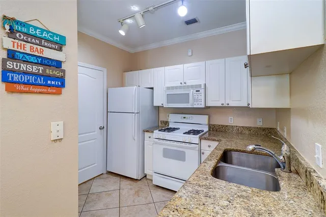 a kitchen with stainless steel appliances granite countertop a refrigerator sink and stove