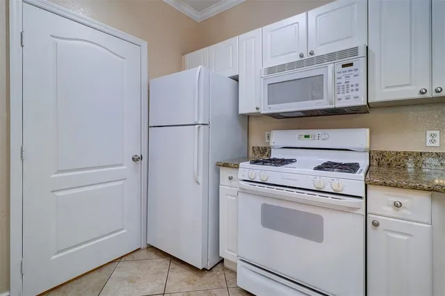 a kitchen with white cabinets and white appliances