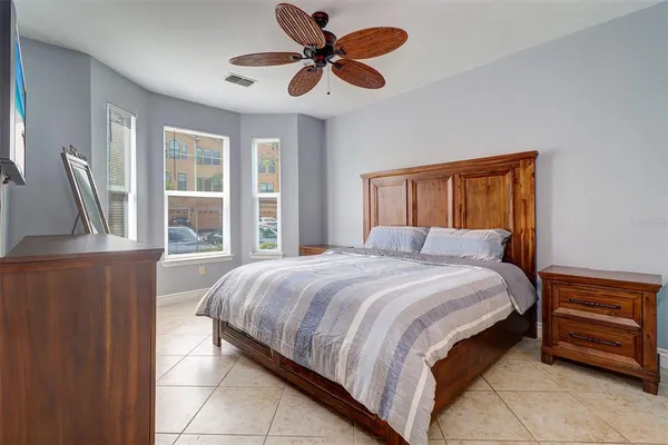 a bedroom with a bed chandelier and a window