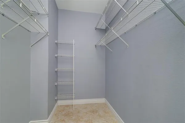 a view of walk in closet with empty racks