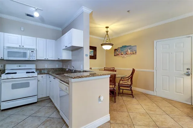 a kitchen with a stove cabinets and chairs