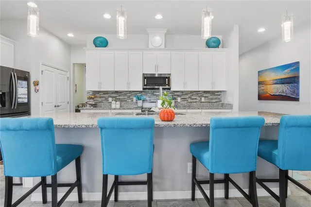 a kitchen with stainless steel appliances a table and chairs in it