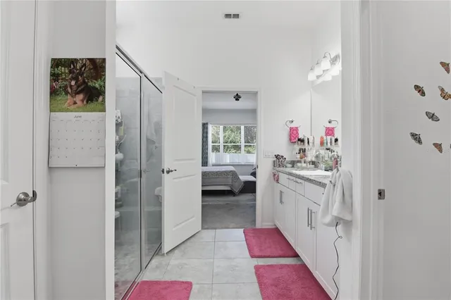 a en suite bathroom with a sink vanity and a mirror