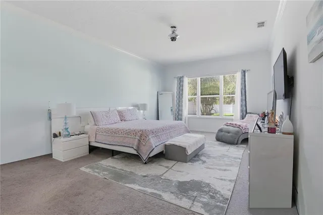 a bedroom with bed and large windows