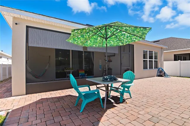 a backyard of a house with table and chairs