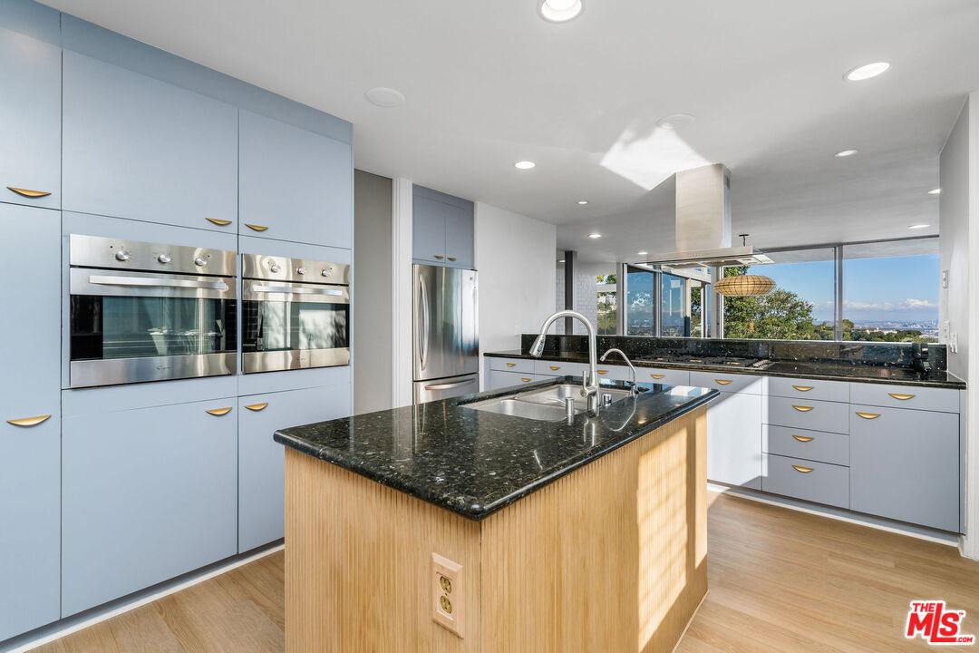 11271 Chalon Road Los Angeles, CA 90049 - Photo 15 of 35 a large kitchen with stainless steel appliances granite countertop a lot of counter space and a sink