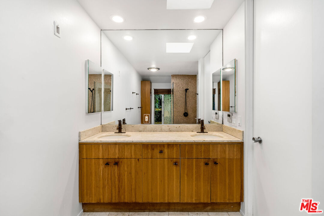 11271 Chalon Road Los Angeles, CA 90049 - Photo 19 of 35 a bathroom with a granite countertop sink mirror and double