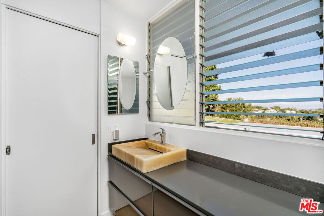 11271 Chalon Road Los Angeles, CA 90049 - Photo 22 of 35 a bathroom with a sink and a mirror