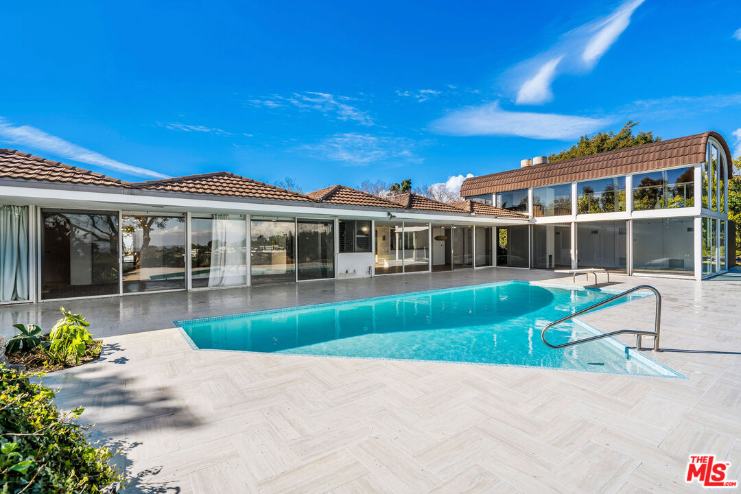 11271 Chalon Road Los Angeles, CA 90049 - Photo 3 of 35 a front view of a house with a yard table and chairs