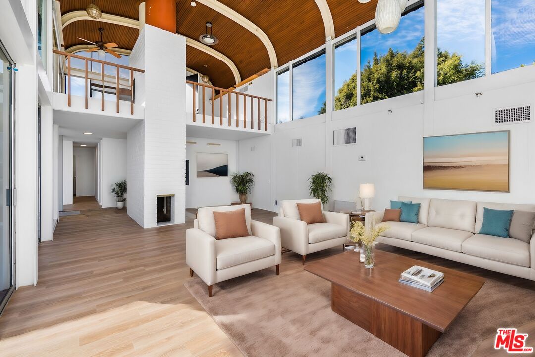 11271 Chalon Road Los Angeles, CA 90049 - Photo 6 of 35 a view of a patio with couches table and chairs with wooden floor