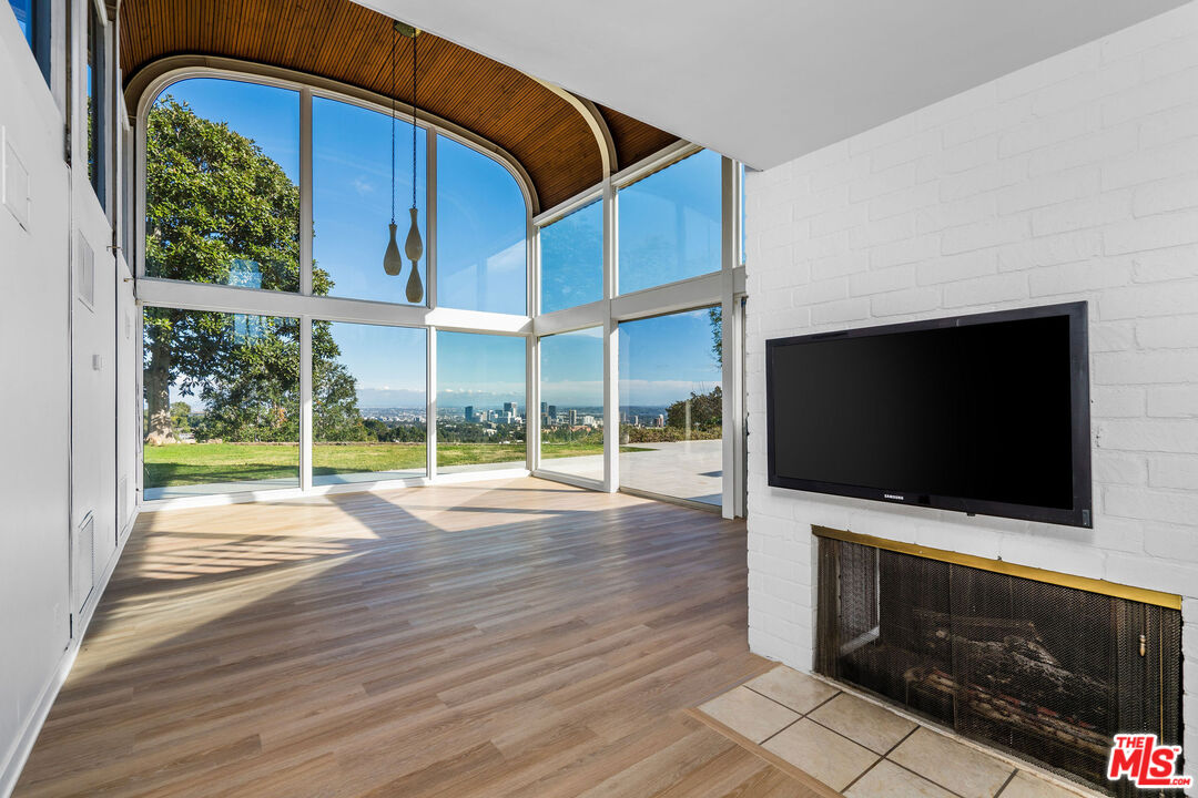 11271 Chalon Road Los Angeles, CA 90049 - Photo 8 of 35 a view of an empty room with a flat screen tv and floor to ceiling window