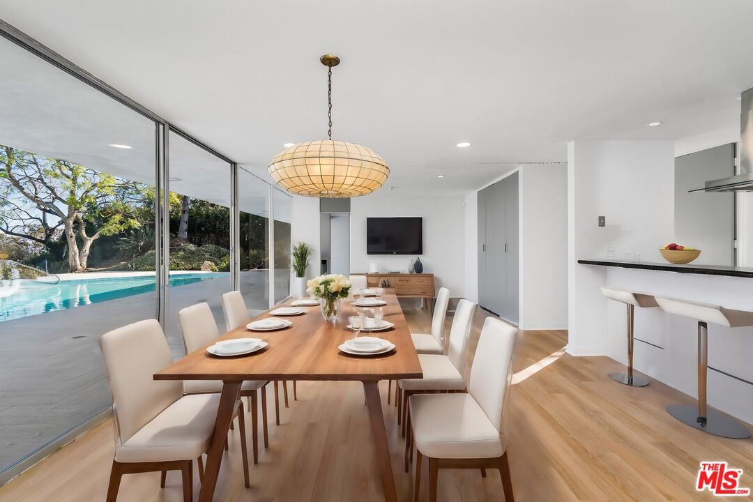 11271 Chalon Road Los Angeles, CA 90049 - Photo 10 of 35 a view of a dining room with furniture wooden floor and chandelier