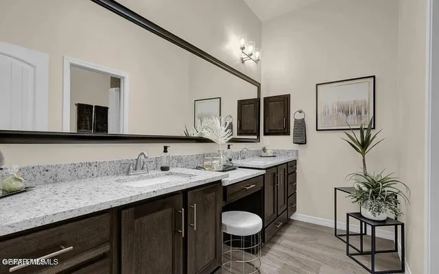 a bathroom with a granite countertop sink a mirror and a toilet