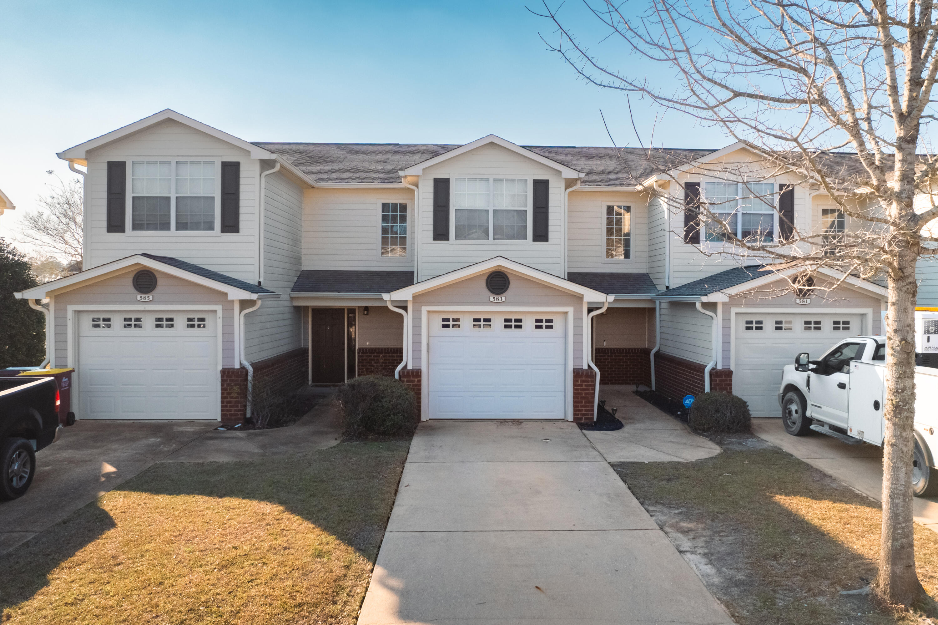 a view of a white house with a large space in front of it